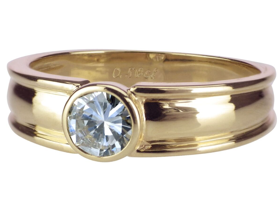 Goldener Ring mit rundem, funkelndem Diamanten in mittiger Fassung, schlichtes und elegantes Design.